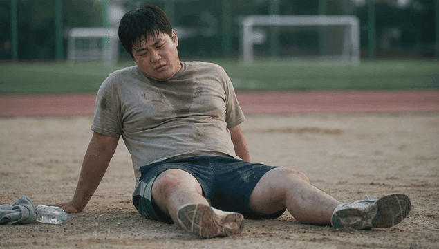 Tired, obese man resting on track field