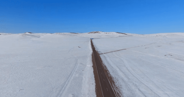 눈 덮인 평원을 가로지르는 긴 도로