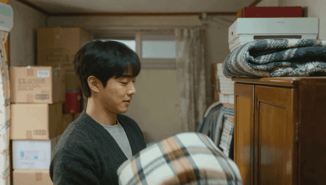 방에서 담요를 정리하는 젊은 남자