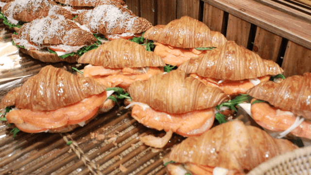 Smoked salmon croissant sandwiches on display in bakery