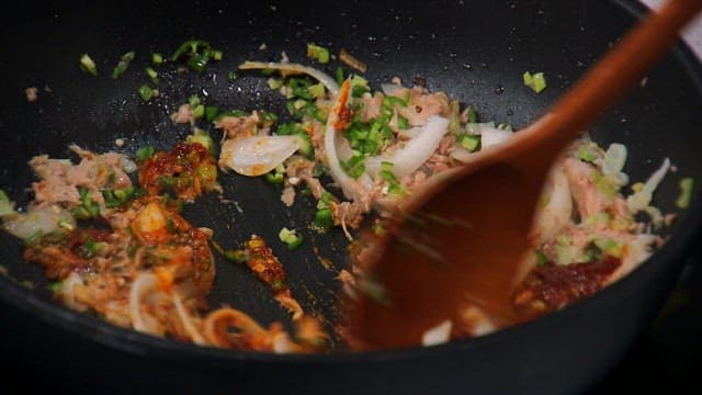 뜨거운 프라이팬에서 양파와 참치를 볶기