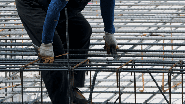 Construction worker handling rebar