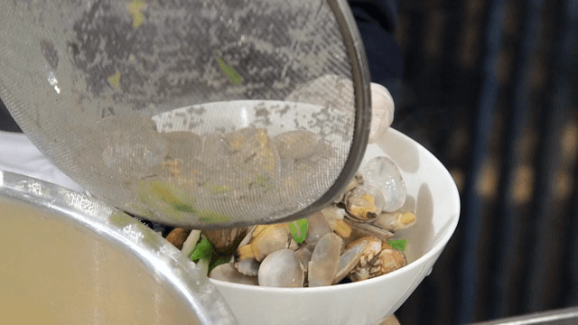 그릇에 담긴 칼국수에 바지락 추가