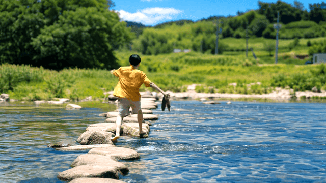 Back view of man crossing stepping stones in summer river