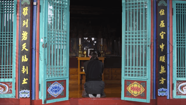 전통 사찰에서 기도하는 사람