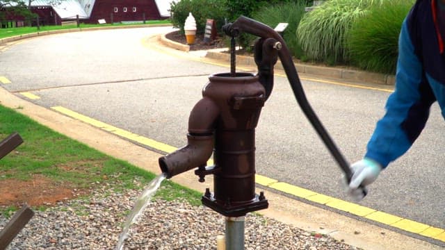 사람이 직접 작동시키는 시골의 수동 펌프