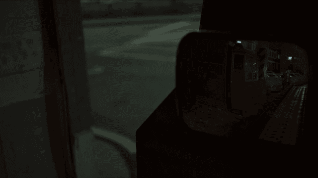 밤에 사람이 안내해서 들어가는 주차장을 비추는 사이드미러