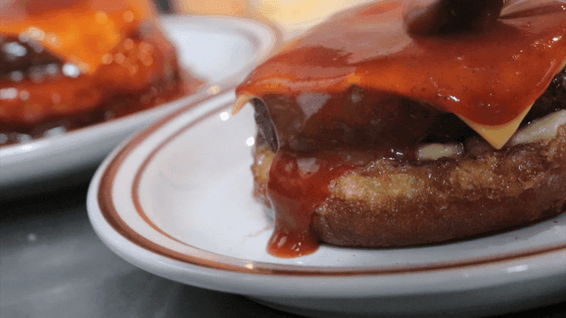 버거 위에 소스를 뿌리는 장면