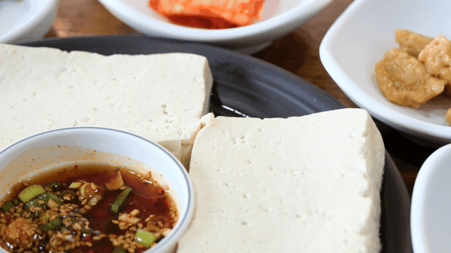 Tofu served with seasoning sauce and side dishes