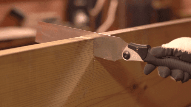 Cutting a wooden plank with a saw