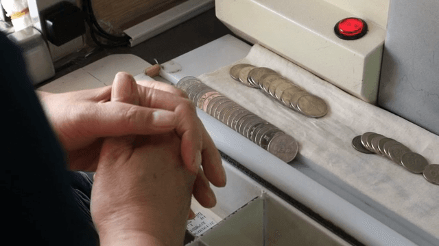 동전 계수기 옆에 손을 모은 모습