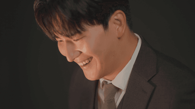 정장을 입은 남자가 금괴를 살펴보는 모습