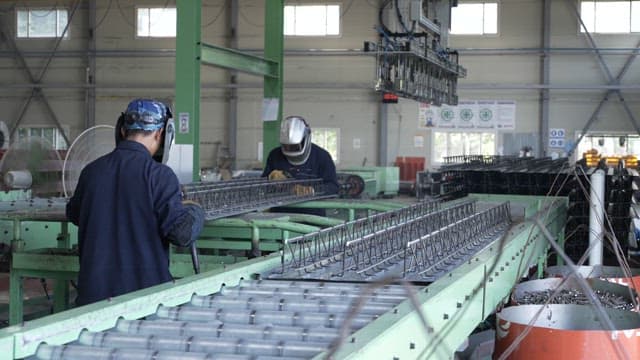 Workers welding in a factory