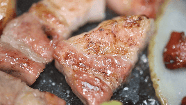 Sizzling pork belly and vegetables on a grill