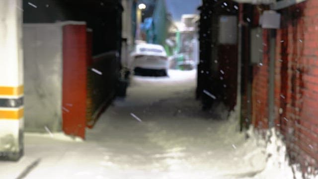 Snowfall in a narrow alley at night