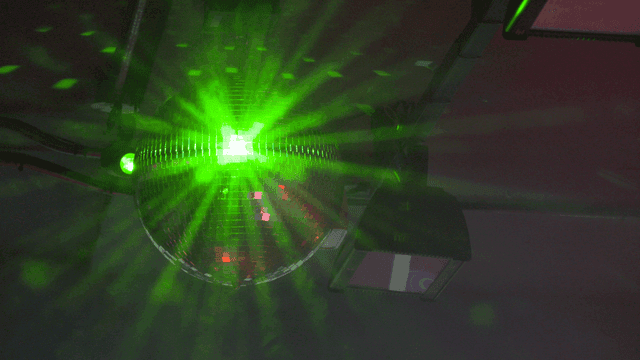 Green disco ball under ceiling lights