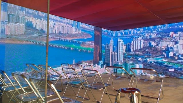 도시 풍경이 벽에 투영되고 투명한 의자가 있는 방