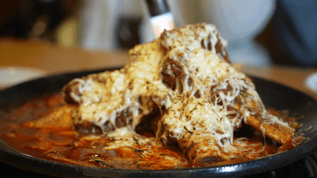Braised short ribs covered in cheese grilled with torch