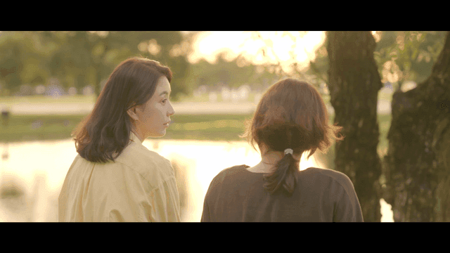 Two women having peaceful conversation by lake