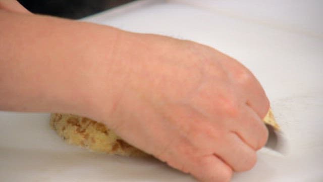 Slicing a freshly baked pancake on a cutting board