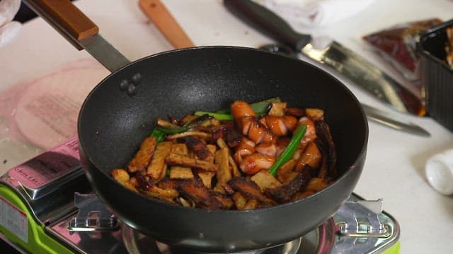 Stir-fried Sausage and Mushrooms Cooked in a Pan on a Gas Burner