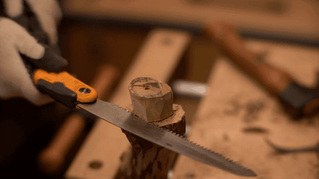 작업장에서 나무를 조심스럽게 톱질하는 모습