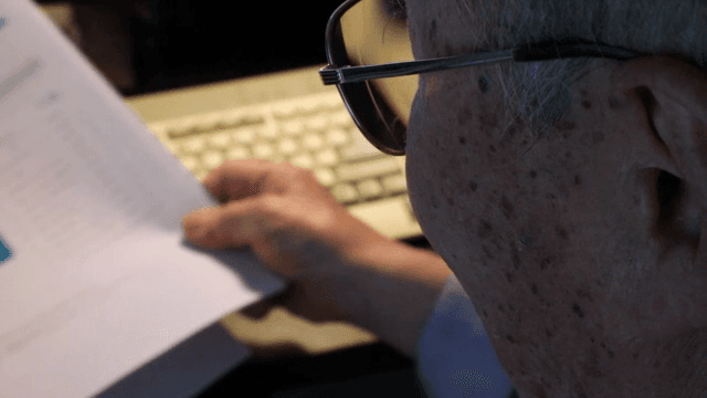 책상에서 문서를 읽는 노인