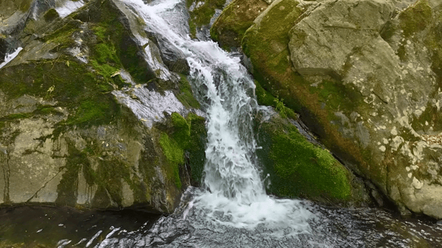 이끼 낀 바위를 흐르는 작은 폭포