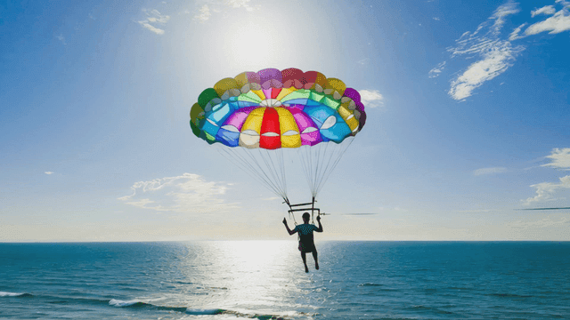 Paragliding over sea under clear sky