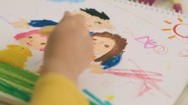 Child Drawing Portraits of Family with Crayons