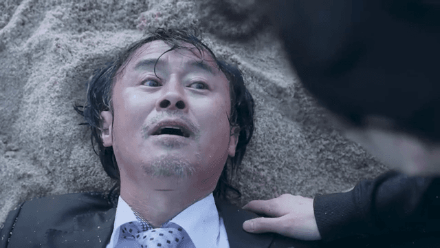 Man lying on sand with eyes closed