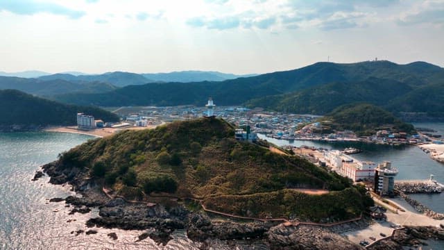 Coastal town with a lighthouse on a hill