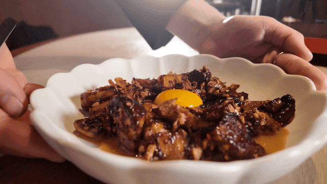 Mushroom dish topped with egg yolk, served on plate