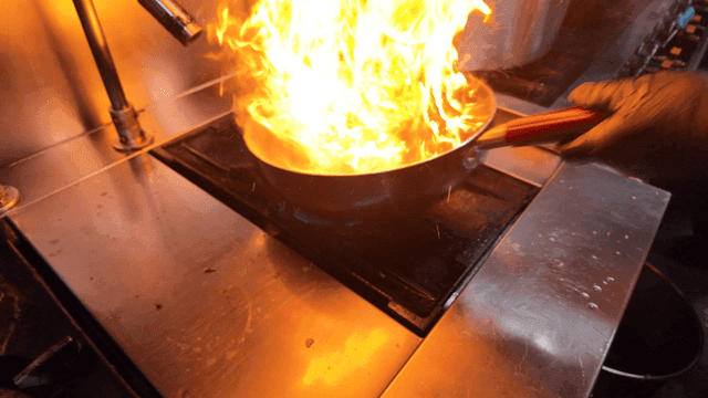 Cooking octopus in a pan with flames