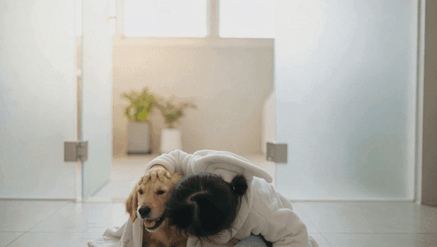 Girl and a dog in bathrobes indoors