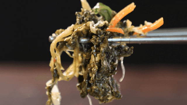 Seasoned dried radish greens picked up with chopsticks