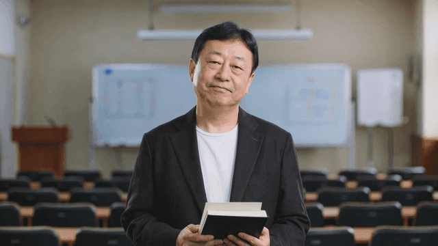 Professor holding book in classroom