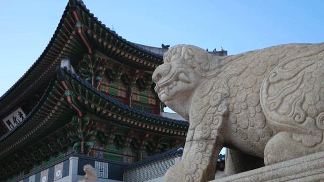 Stone Statue by Traditional Korean Architecture