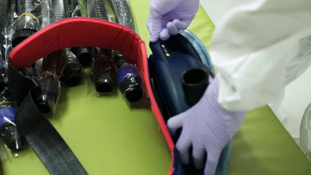 방호복을 착용한 사람이 의료 장비를 다루는 모습