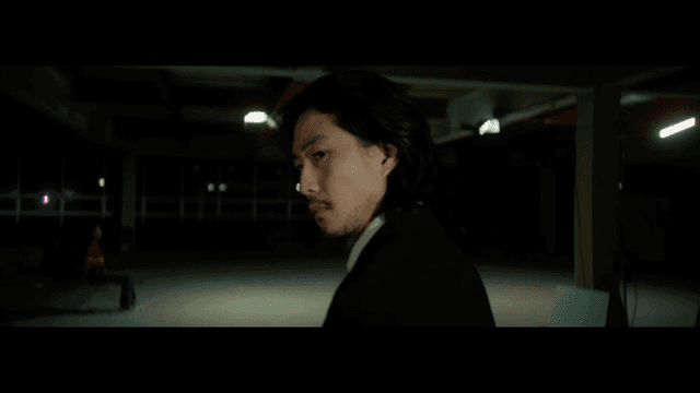 어두운 방에서 걷고 있는 정장 입은 남자