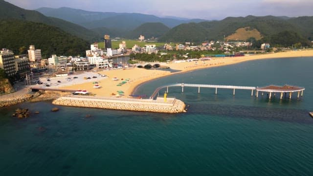 Scenic beach with a pier and nearby town