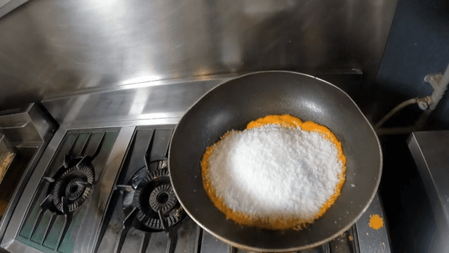 Adding salt to a pan with paprika sauce
