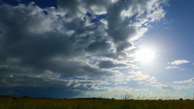 Sunlight Piercing Through Cloud Flowing over the Meadow