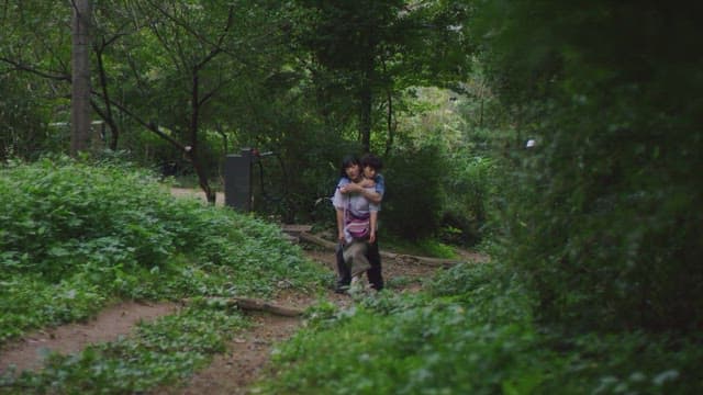 숲길을 따라 걸으며 대화하는 커플