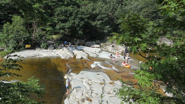 화창한 날 산중 계곡에서 피서하는 사람들