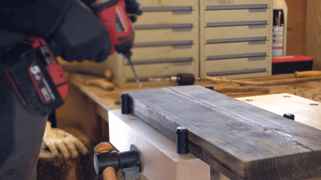 나무 판자에 드릴을 사용하는 사람