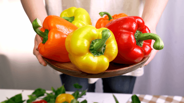 Person holding variety of colored peppers