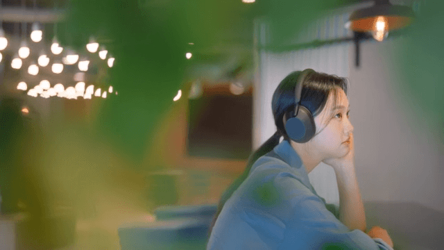 실내에서 헤드폰으로 음악을 즐기는 여성