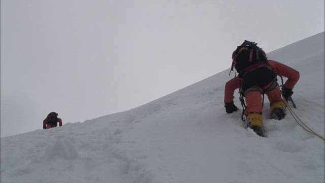 Climber Ascending a Snowy Mountain Slope