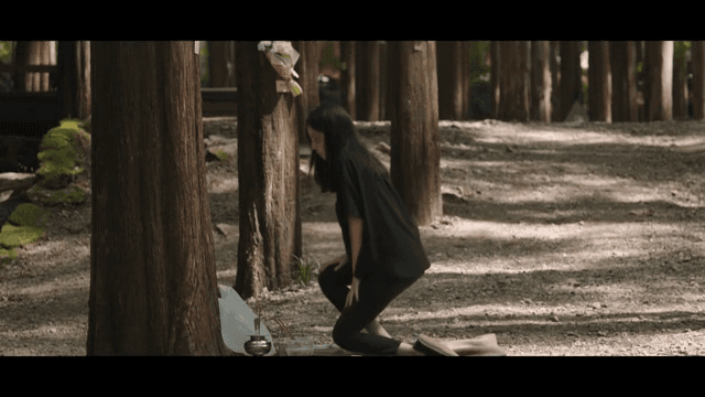 숲 속에서 추모를 하는 여성